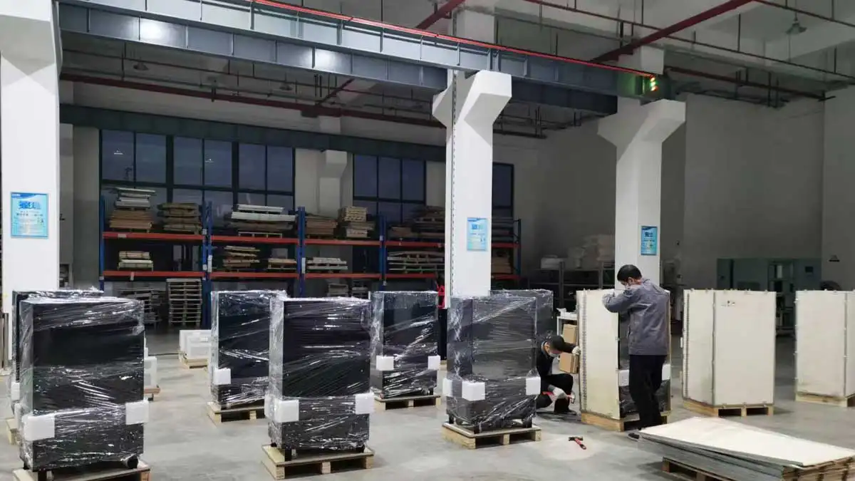 Converter cabinets on pallets with protective wrapping and foam, with wooden crating in progress.