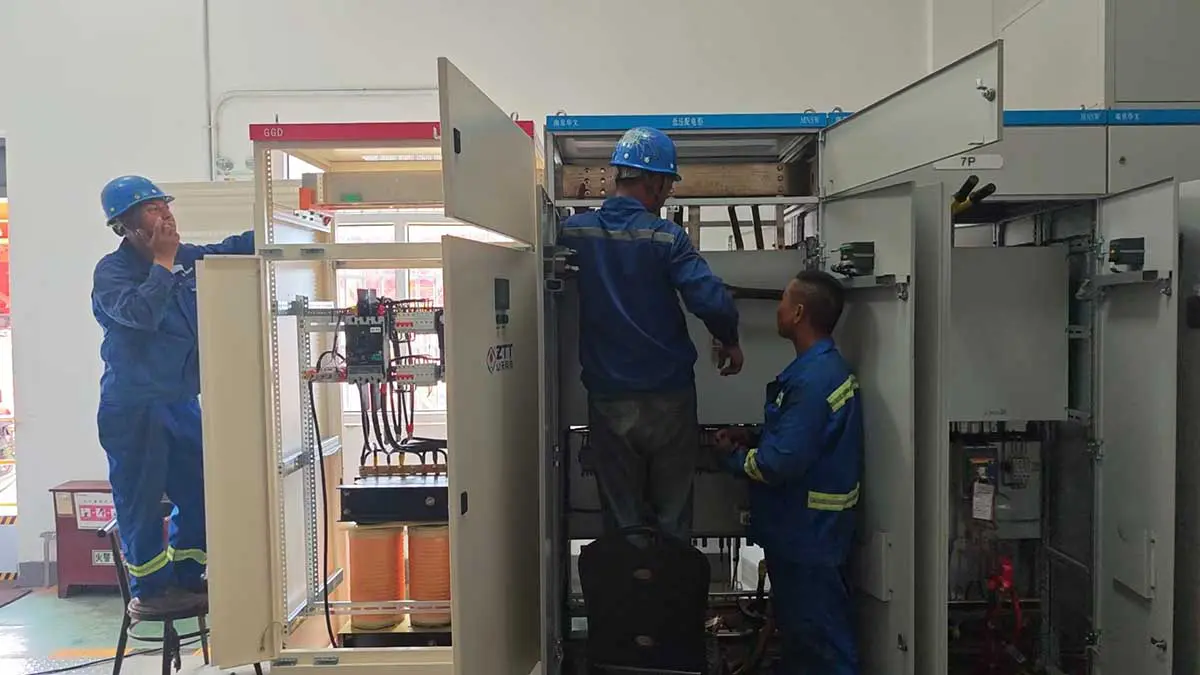 Engineers measuring the existing busbar interface before fabricating the connection pieces