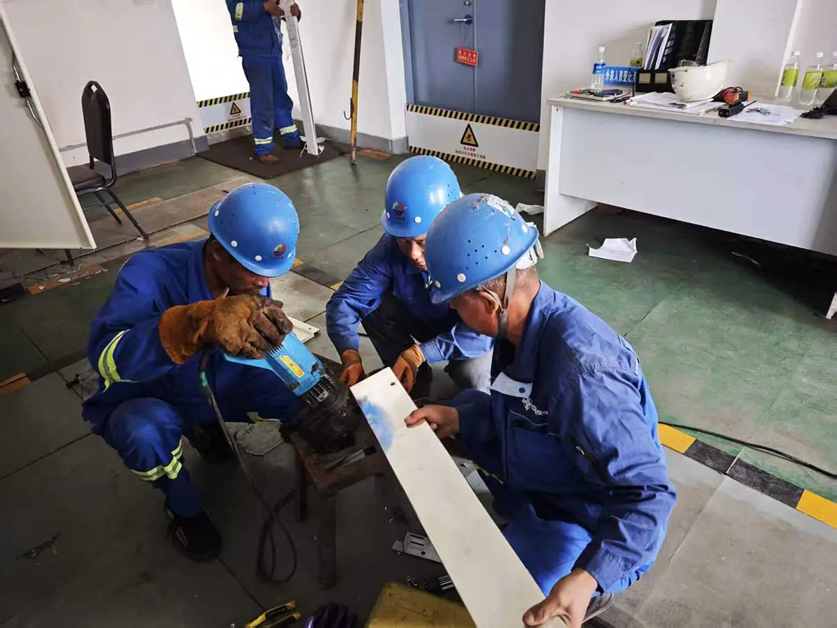 Installation team fabricating a busbar connection piece to match the measured cabinet interface