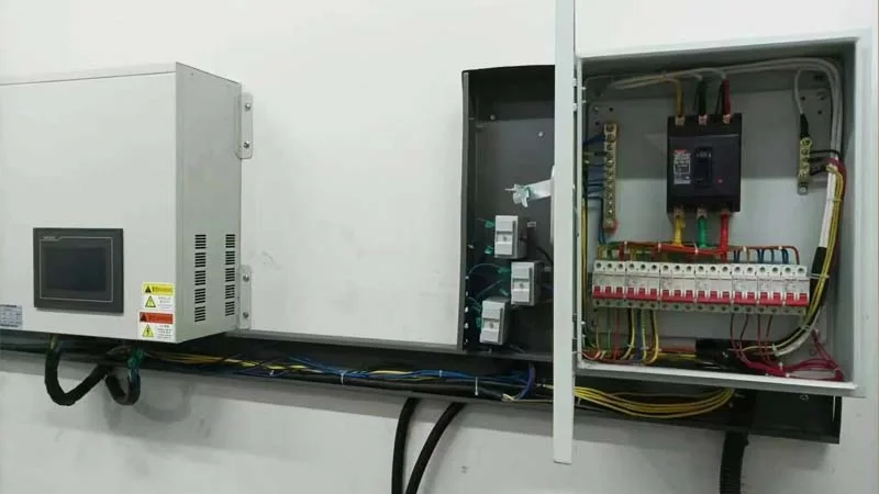 Wall-mounted AHF equipment beside an open distribution panel with field wiring visible