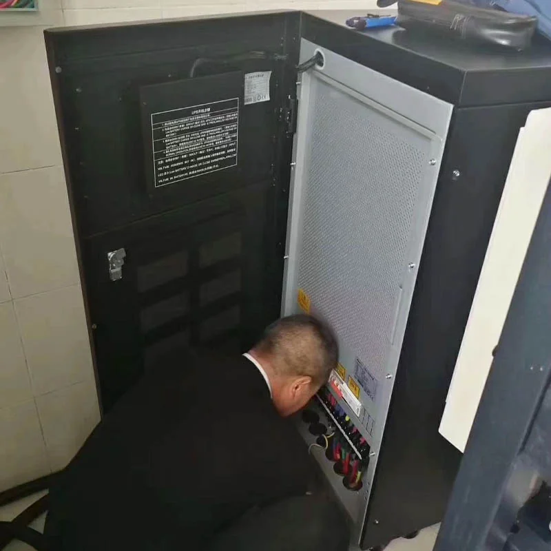 Technician completing electrical connections on a UPS cabinet