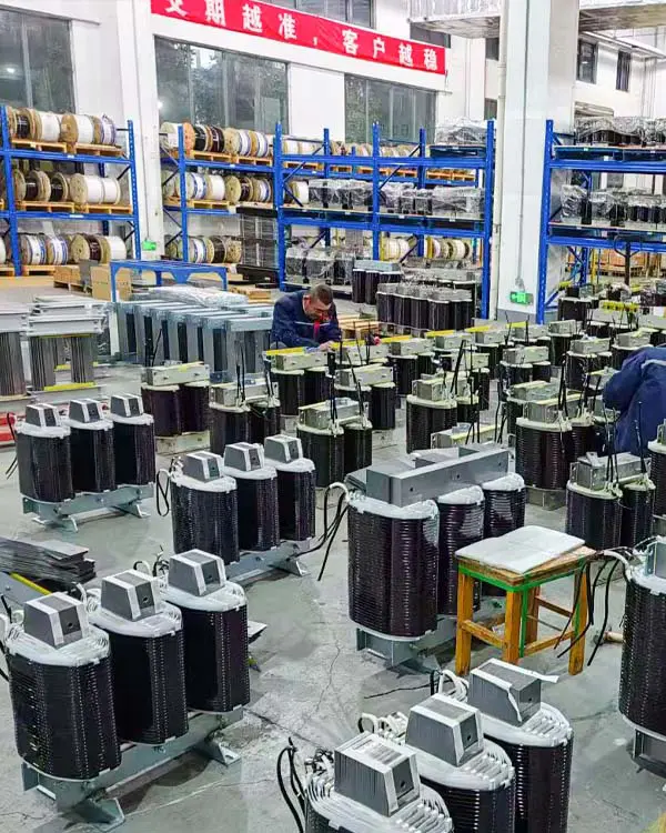 Workers assembling transformer cores and windings during three-phase isolation transformer production